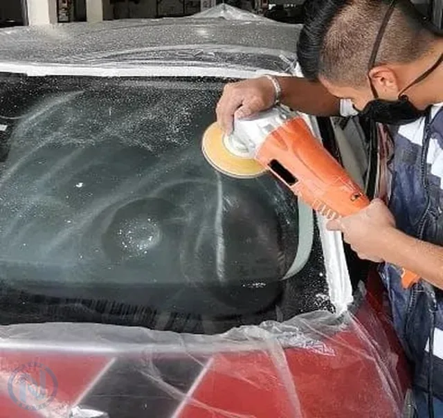 Técnico restaurando un parabrisas con equipo especializado